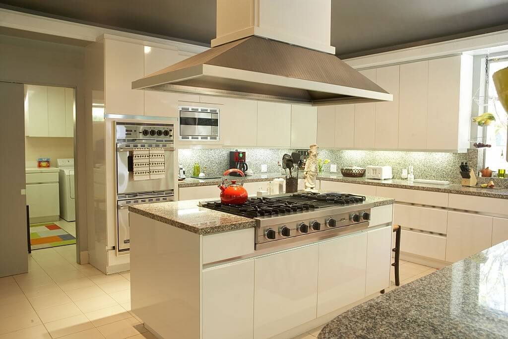 duży okap w jasnej kuchni, nad wysepką